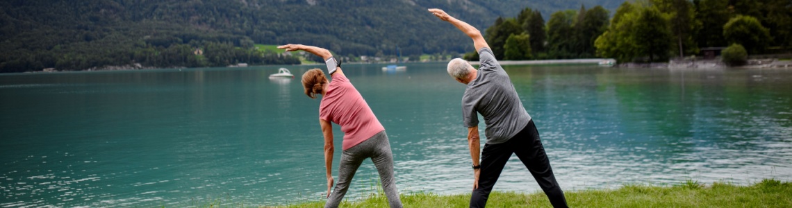 Couple doing tai chi by a lake
