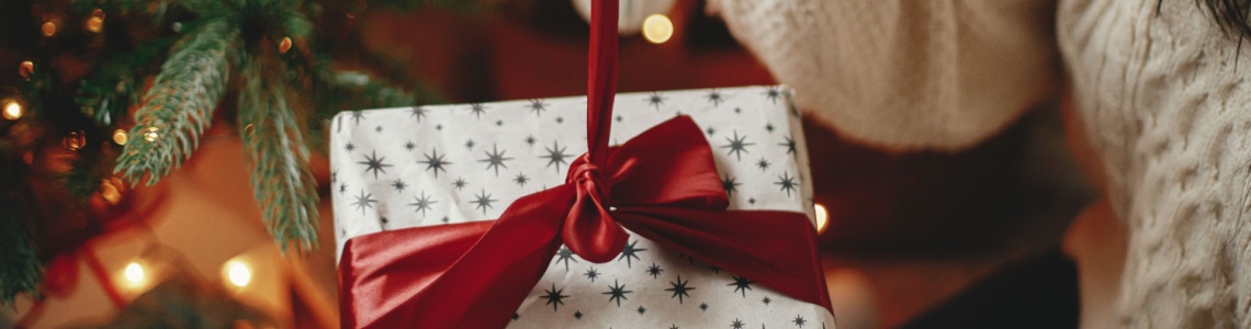 A woman untying a ribbon on a Christmas present.