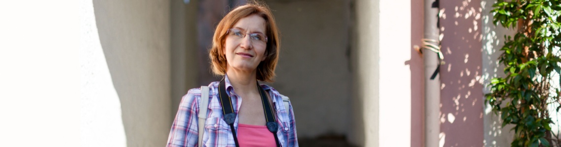Woman on an urban street holding a camera
