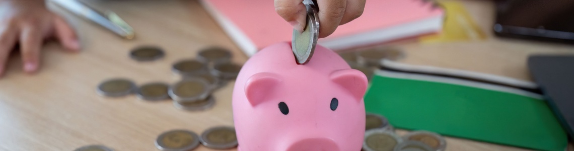 Child putting coins into a piggy bank