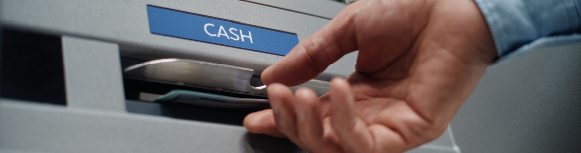 A person using an ATM to withdraw cash.