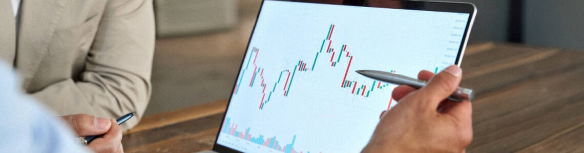 A man reviewing stock market movements on a laptop.