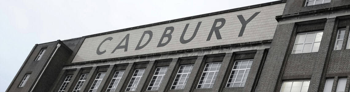 greyscale image of old English building with Cadbury sign across the front